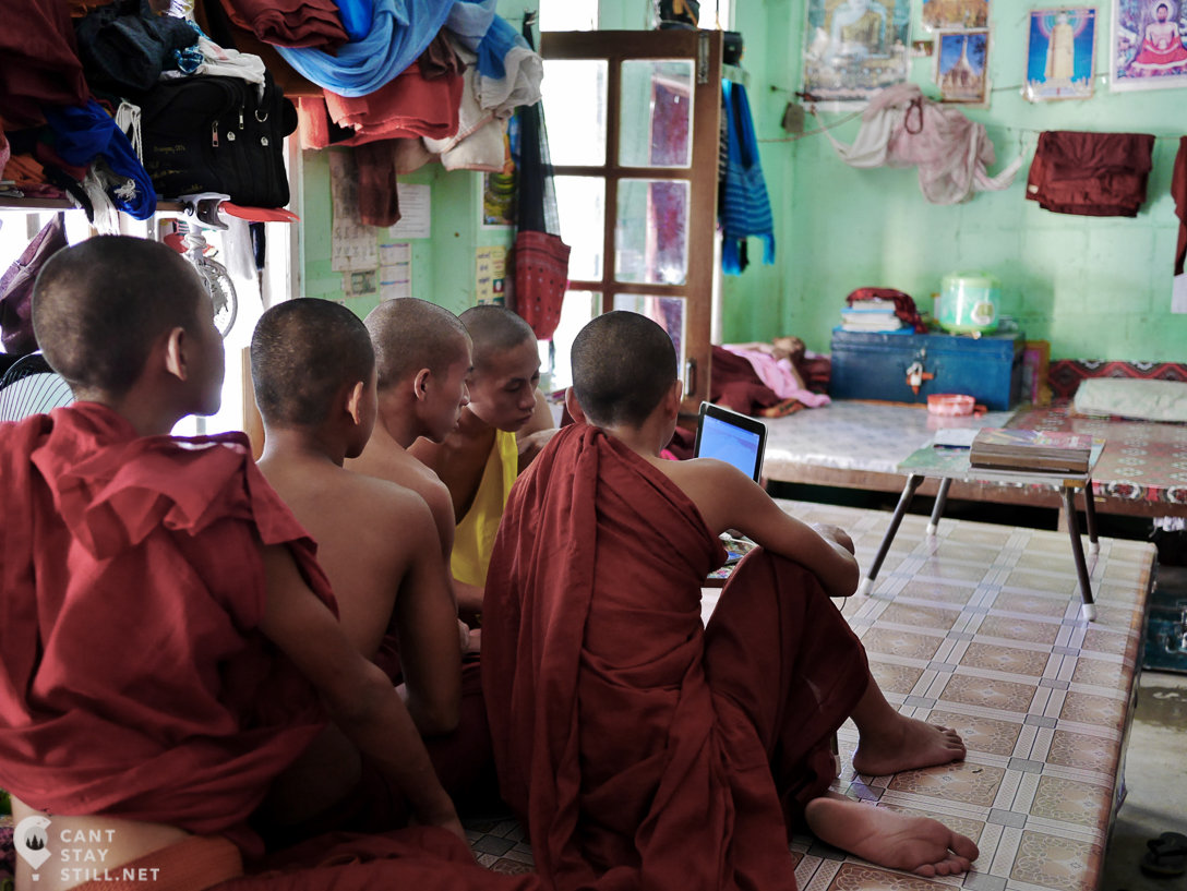 novice monks hanging out in one of the bedrooms, watching a movie at a monastic school in Mandalay, Myanmar